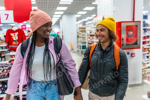 Preview: Diverse young couple holding hands walking in store
