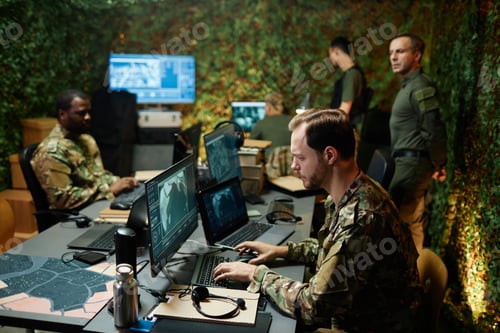 Preview: Side view of young male military officer typing on keyboard