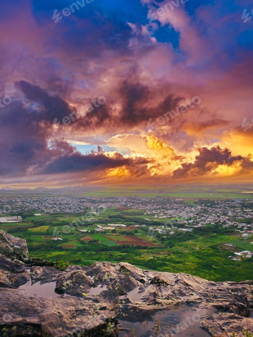 Preview: Sprawling grassy landscape surrounded by lush fields and illuminated by a cloudy sunset sky.