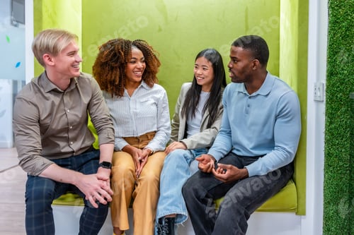 Preview: Multi ethnic team enjoying conversation in coworking space