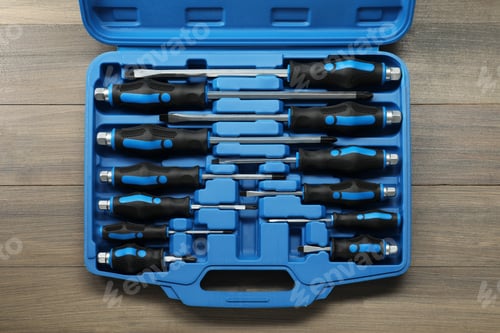 Preview: Set of screwdrivers in open toolbox on wooden table, top view