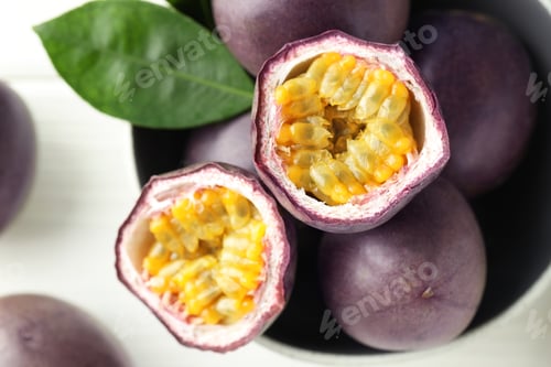 Preview: Fresh passion fruits in bowl on white table, top view