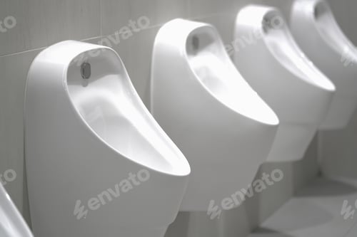 Preview: Close up row of indoor urinals men. toilet room interior background on modern tower.