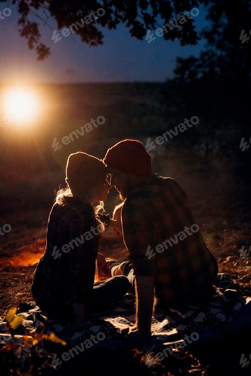 Preview: Young couple a guy and a girl in bright knitted hats stopped at a camping