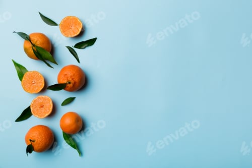 Preview: Many fresh ripe mandarin with green leaves on colored background, top view, space for text