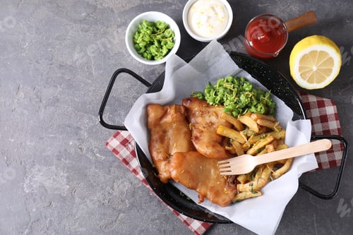 Preview: Tasty fish, chips, sauces and peas on grey table, flat lay. Space for text