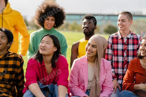 Preview: group multiracial friends sitting in park talking happy