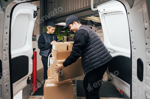 Preview: Side view male courier loads cardboard boxes from cart