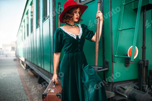 Preview: Woman in red hat against old railway wagon