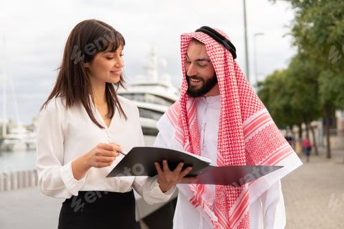 Preview: Friendly diverse man and woman reading contract