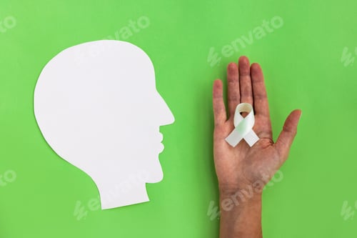 Preview: Brain paper cutout with green ribbon on green background with copy space. Mockup for world mental