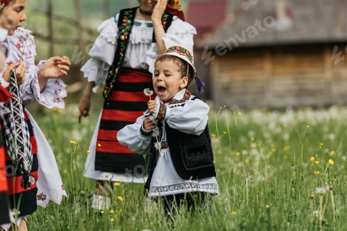 Preview: Little boy dressed in traditional costume, playing with dandy lions.