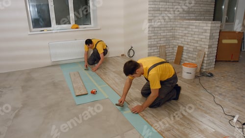 Preview: Builders installing laminate floor.
