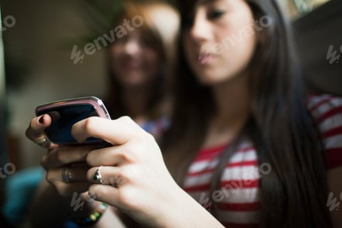 Preview: Two teenage girls using smartphone