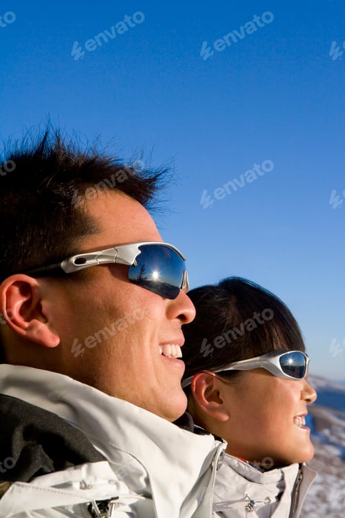 Preview: Close-up of a young man and young woman in sunglasses smiling