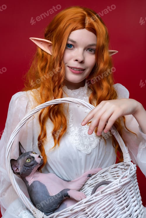 Preview: Portrait of young redhead woman cosplayer elf with wicker basket in hands on red background