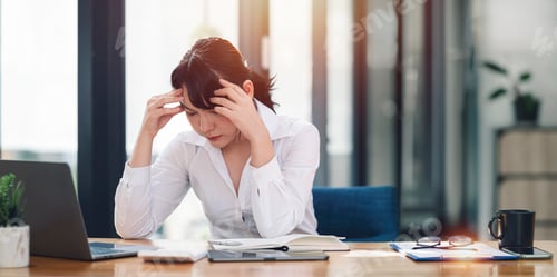 Preview: businesswoman working on laptop computer, stressed has a headache from work at the office.