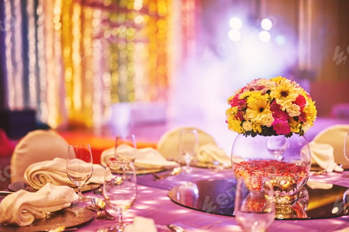 Preview: Wedding reception dinner table with flower bouquet decoration in the indian sangeet night with