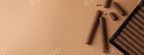 Preview: Plastic box with chocolate wafer rolls on brown background