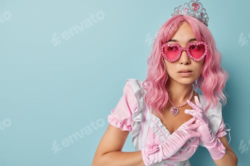 Preview: Pensive pink haired lady wears crown dress gloves and heart shaped sunglasses keeps hands together f