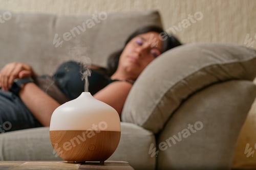 Preview: Young latina woman using aromatherapy to relax. Wellness concept.