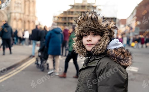 Preview: Kid boy standing on city street with blurry people in winter,Happy kid with winter warm cloth