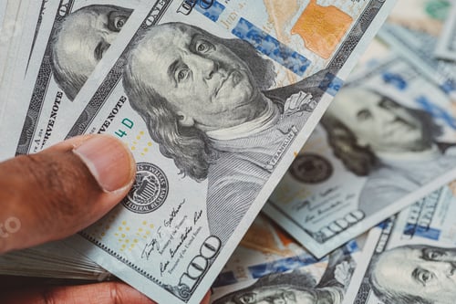 Preview: African American or black man at home counting money wealth and saving concept