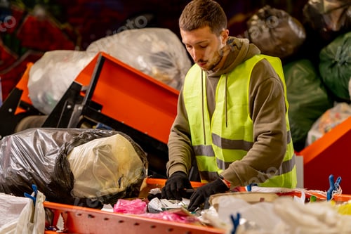 Preview: man in uniform working on a garbage distribution line and sorting waste into special containers