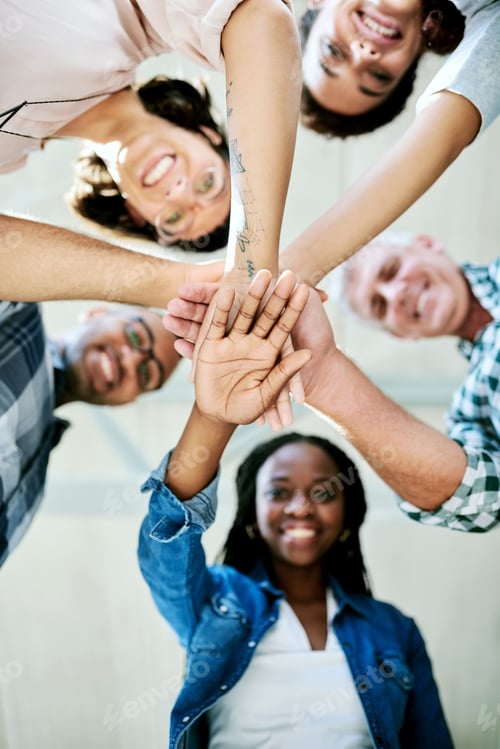 Preview: Fuel your vision with perseverance. Shot of a group of creatives stacking their hands in unity.