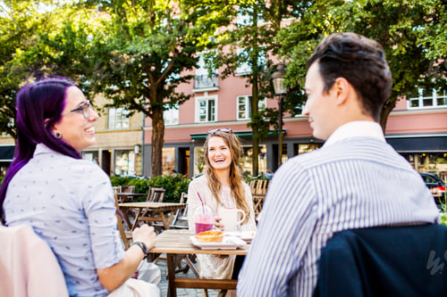 Preview: Friends laughing and chatting at an outdoor cafe