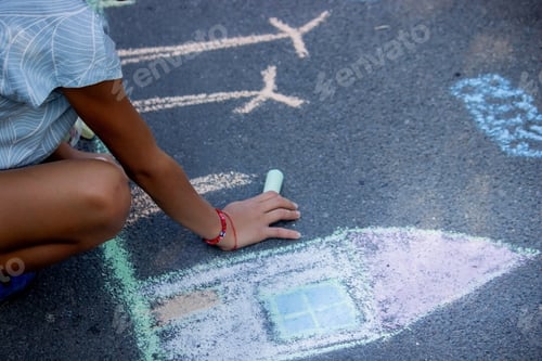 Preview: a child draws with chalk on the asphalt. beautiful picture
