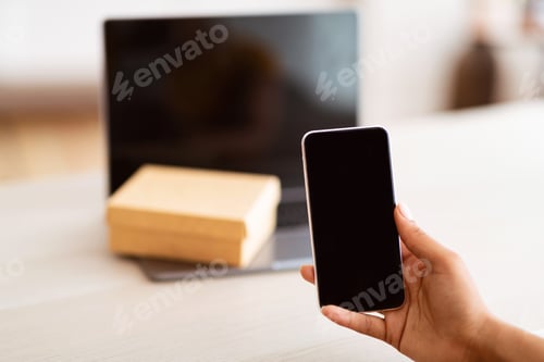 Preview: Black woman showing smartphone with blank empty screen