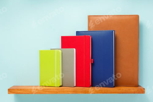 Preview: notepad and book on shelf at wall background