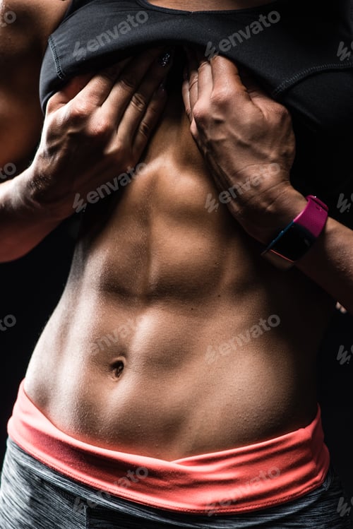 Preview: Close-up of the abdominal muscles young athlete on black background
