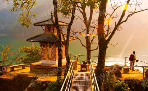 Preview: Rear view of tourist near lake at sunset