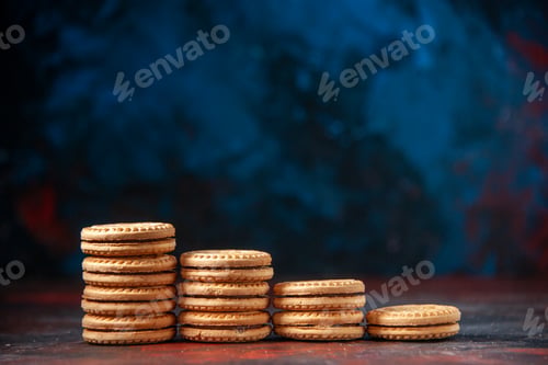 Preview: Side view of delicious cookies stacked in different numbers on mix colors background