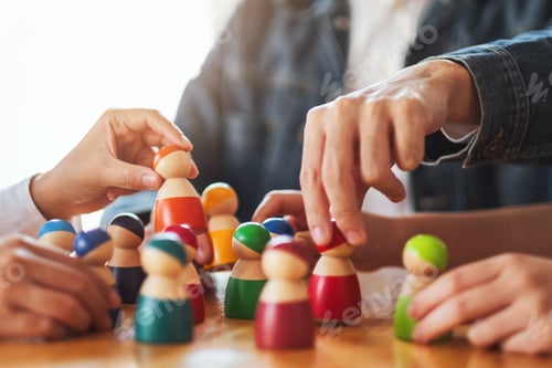 Preview: People choosing and picking up wooden figure from a group on the table