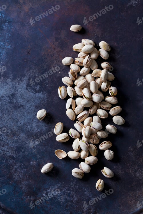 Preview: Roasted and salted pistachios on dark metal