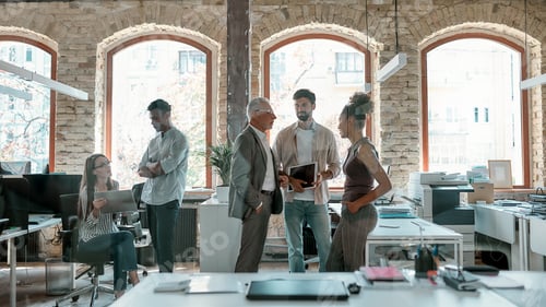 Preview: Discussing new project. Group of modern people having a meeting while standing in the creative