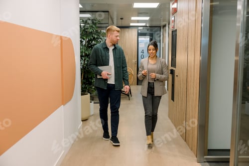 Preview: Business professionals walking and talking in office hallway