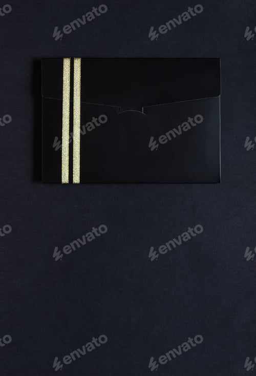 Preview: black envelope mockup, Flat Lay, on black background with copy space. Tied with a gold ribbon.