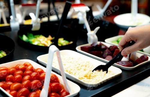 Preview: Hand holding spoon to scoop boiled Job's tears at salad bar. Salad bar buffet at the restaurant.