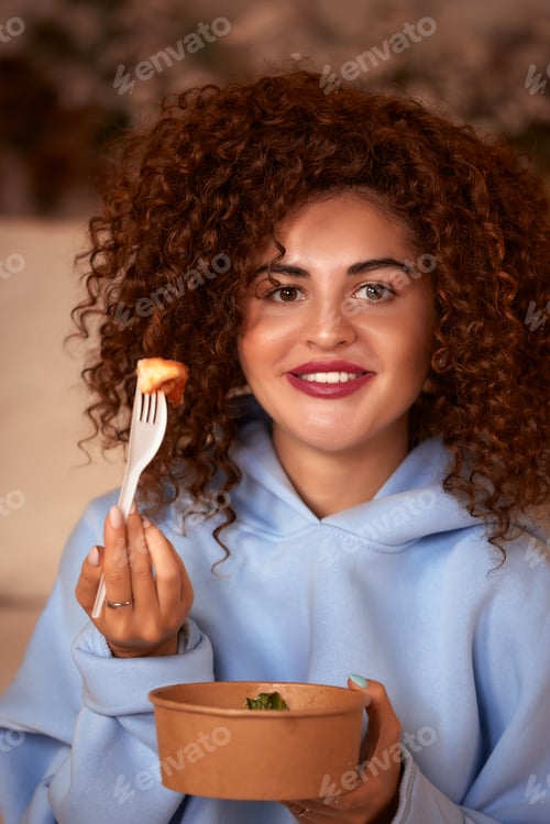 Preview: Young woman eating sushi at home. Home food delivery concept. Japan food. Top view. Space for text
