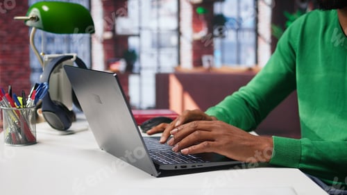 Preview: African american teleworker typing ideas to create a vision board on laptop