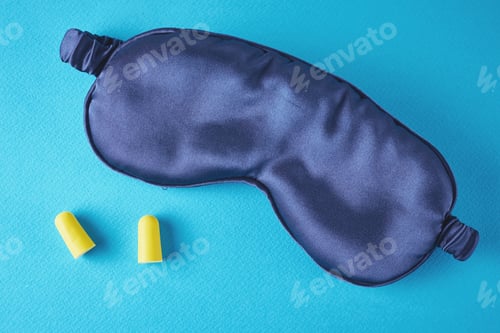 Preview: Insomnia and sleeping problem concept.Sleeping mask and ear plugs on a blue background, top view