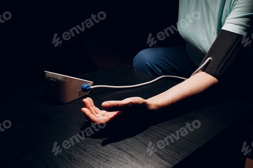 Preview: Senior woman taking measures blood pressure at home. Self care of elderly health.