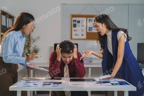 Preview: Two angry female coworkers are scolding a stressed businessman during an office meeting about bad fi