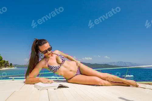 Preview: Woman Lounging on Boat Reading Book, Relaxing