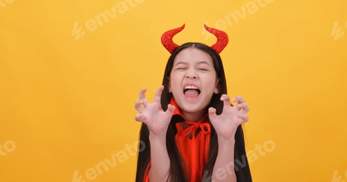 Preview: Cute little girl wearing a witch costume to celebrate Halloween on yellow background.