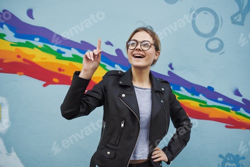 Preview: pretty woman on the street near the colorful wall walking in the city